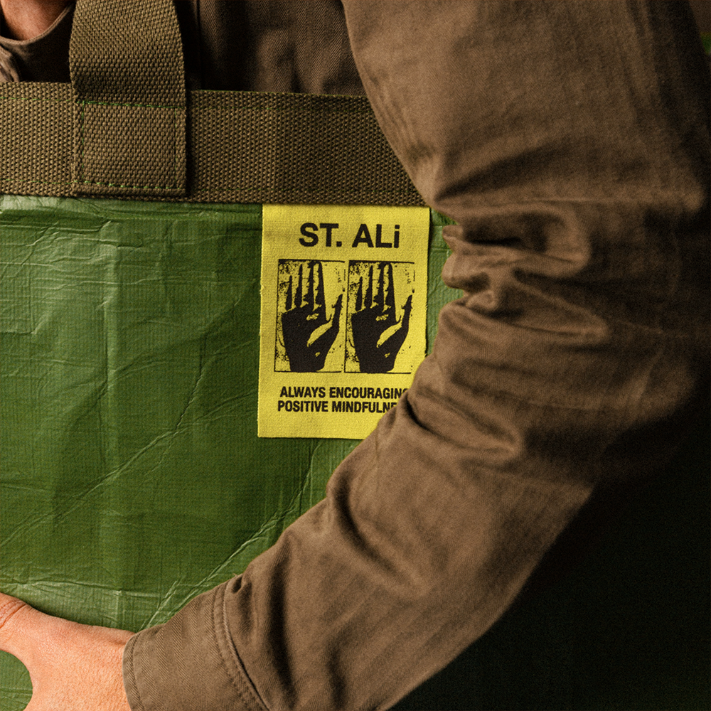 Green tote back with yellow ST. ALi tag being held